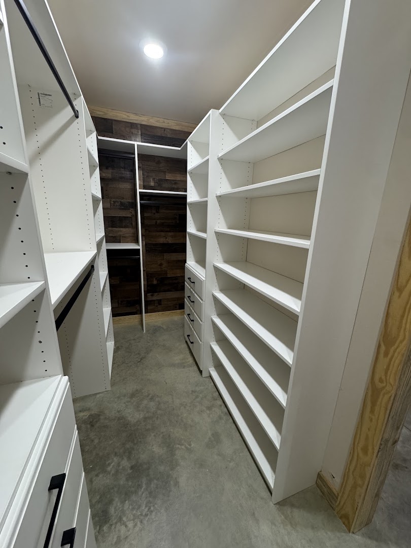 Custom white walk-in closet with open shelving and drawers